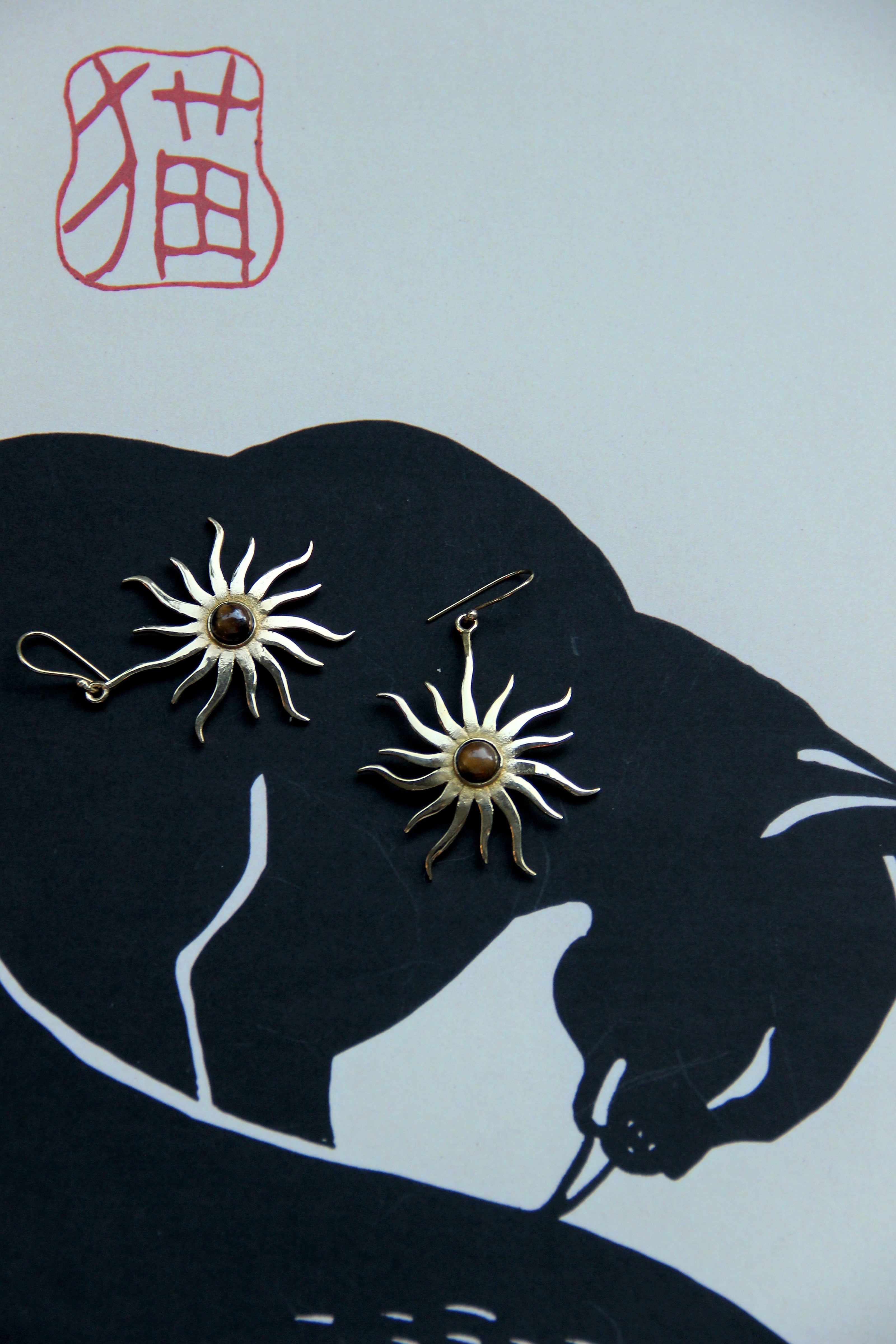 Gold toned brass sun earrings